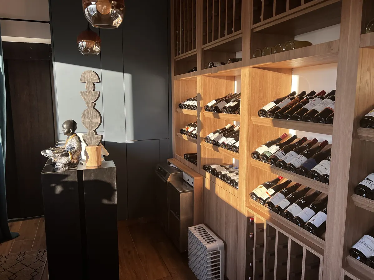 La cave de Tadaima : casiers en chêne garnis de grands vins, sous la lumière du soir