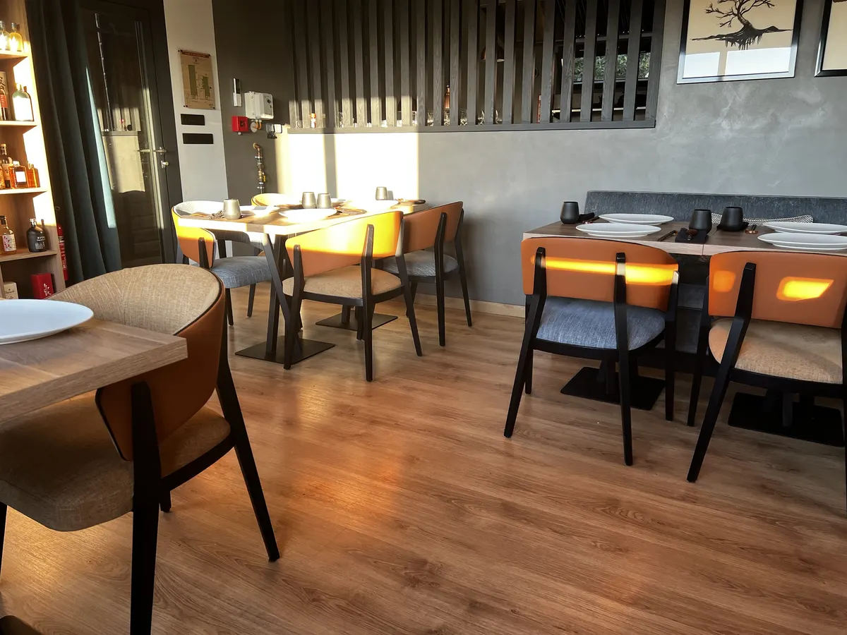La salle de Tadaima : chaises cuir cognac, tables en bois et claustra, sous le soleil de fin de journée